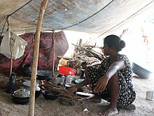 IDP woman in a temporary kitchen. Much of the displaced civilians were often forcibly detained in camps lacking even the basic amenities. Refugee woman in Sri Lanka cooking.jpg