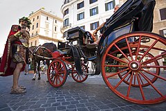 A man dressed as a roman soldier standing near horse drawn carriages in Piazza Spagna. Rome, Italy