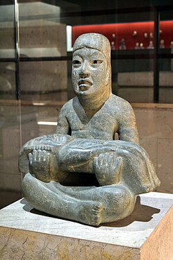 Las Limas Monument 1, considered an important realisation of Olmec mythology. The youth holds a were-jaguar infant, while four iconic supernaturals are incised on the youth's shoulders and knees. Senor de las limas 2.jpg