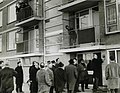 Wethouder van der Borg schroeft het eerste huisnummerbord in Nederland met zowel straat als huisnummer in cijfers op een flatgevel (1967)