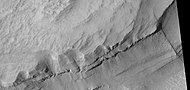 Vista cercana de las capas, como las ve HiRISE en el programa HiWish Una cresta atraviesa las capas en ángulo recto.