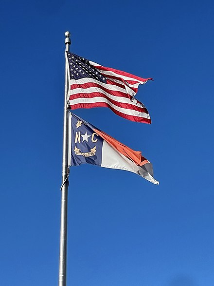 Star-spangled banner above the North Carolina flag.