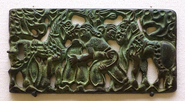 Belt plaque with design of wrestling men, Ordos region and western part of North China, 2nd century BC, bronze - Ethnological Museum, Berlin. Accordin