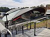 Picture of Cherrybrook station viewed from the outside. It consists of a curved roof covering platform in a cutting below ground.