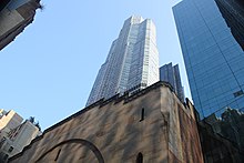 City Center, a sandstone building with a dome, as seen from the ground on 55th Street. Behind it is CitySpire, a glass-and-metal skyscraper.