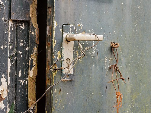 Rickety wooden door in a dilapidated shed on the Famberhorst. (door handle)