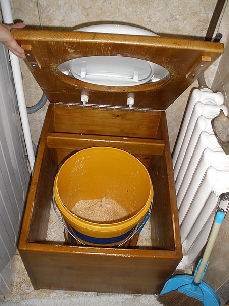 Inside view of a bucket toilet in Ulaan Baatar, Mongolia. The bucket has a layer of sawdust at the bottom.