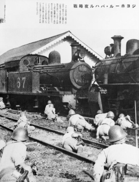 Japanese troops take cover behind steam engines at the Johor railway station in January 1942.
