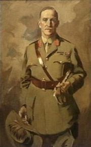Painting of man in khaki uniform wearing a Sam Browne belt, jacket with two rows of ribbons and red tabs, and a tie. He is holding a slouch hat with emu feathers in one hand, and a swagger tucked under his left arm.