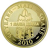 Moeda em ouro estampada com o desenho de uma torre ao pé da qual se lê "Mansa Moussa".