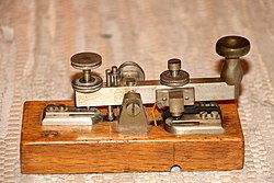 A telegraph key used to transmit text messages in Morse code Morsetaste.jpg