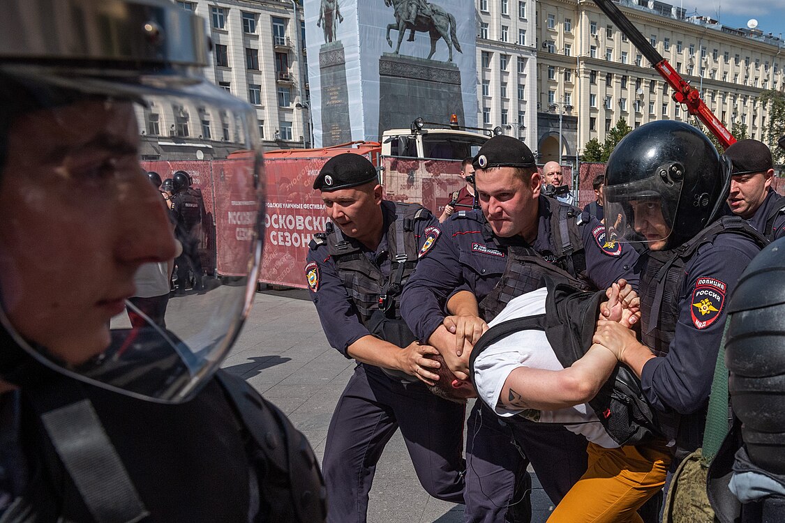 Люди в штатском указывают, кого нужно задержать — как из числа участников, так и просто прохожих