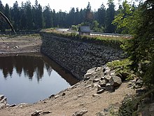 Blick von Nordwesten auf das wasserseitige Mauerwerk des Dammes bei stark entleertem Stauraum