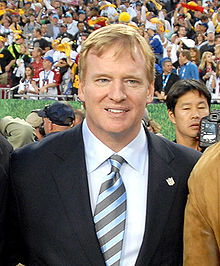 A man in a tuxedo with a blue and grey tie.