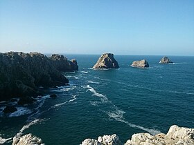 La punta lanza audazmente al mar de Iroise la proa de su alto acantilado de cuarcita (90 m) extendido por una cadena de islotes y arrecifes, el Tas de Pois, vestigios del acantilado original.