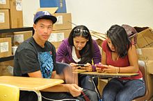 Two girls text during class at school. Textinginclass.jpg