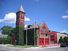Cihlová hasičská stanice s věží a břečťanem roste na budově