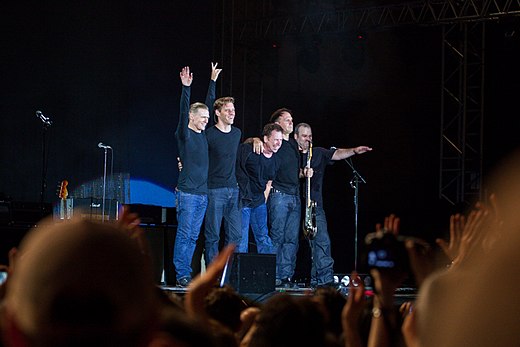The band lineup after a concert in Lucca, Italy in 2013. From left to right: Adams, Gary Breit, Mickey Curry, Keith Scott, and Norm Fisher
