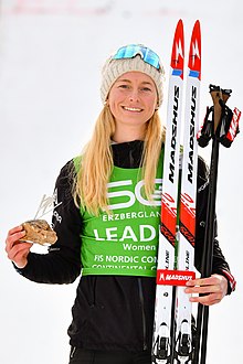 En blond, smilende kvinde med en beanie.