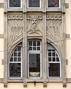 Kosatce a maskaron na fasádě budovy Schichtel od Aloyse Waltera ve Štrasburku, Francie (1905-06)