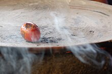 Tomato roasting on a clay comal Barro comal.jpg