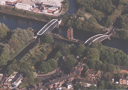 Aerial view of Barton-on-Irwell in 2002 looking SE showing the Barton Swing Aqueduct over the ship canal (left) and the Barton Road Swing Bridge (right)