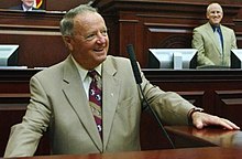 Bobby Bowden in a suit speaking.