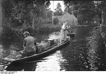Transport de marchandises en canot dans la forêt en 1930
