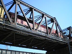 A steel truss bridge with a locomotive on it.
