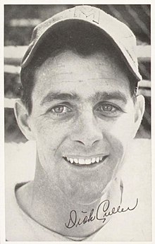 A man win a light baseball uniform and dark cap with an "M" on the center.