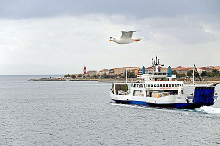 The white and red lighthouse Ferry Zancle approaching Villa San Giovanni - Punta Pezzo lighthouse in the background - 20 Oct. 2010.jpg