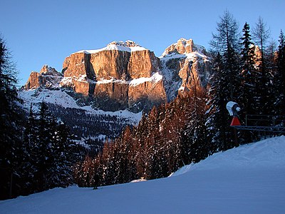 Zimní pohled na skupinu Sella od jihu, zleva doprava věže Sella, Piz de Ciavazes, soutěska Lorenz a Piz Lasties; pozdní odpoledne.