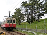 東鳴尾駅付近を走る7861形電車。右側は武庫川の堤防と松の木。 （2013年）