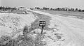 Israël 1948-1949; Negevwoestijn, controlepost. Weg leidend naar een controlepost in de Negevwoestijn, met op de achtergrond een dorp, vermoedelijk Beersjewa (255-0758).A.jpg