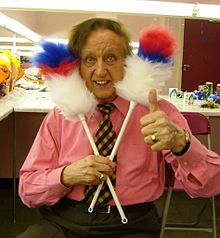 Ken Dodd'un 2007'de soyunma odasında çekilmiş renkli fotoğrafı. Komik bir şekilde kafasına iki tüy silindiri tutuyor.