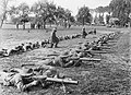 Men of 28th Battalion of the 2nd Australian Division lying stretched on the ground to practice Lewis gun drill at Renescure.