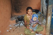 Nepali housewife in her home with child. Nepali Housewife.JPG