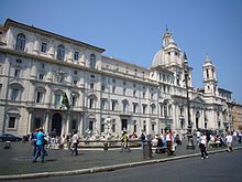 Palazzo Pamphilj on the left, with Sant'Agnese in Agone church on the right, and Fontana del Moro in the foreground. The Serlian windows adjacent to the church open to the Cortona-frescoed gallery. Parione - piazza Navona - s Agnese in Agone e palazzo Pamphilij 1020584.JPG