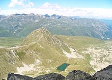 Vue vers le nord depuis le Pic de les Valletes (ou Vinyola), avec le Pic de la Mine sur la gauche, et l'Estany de l'Orri de la Vinyola dans son cirque glaciaire en contrebas. À droite de la Pic de la Mine, des éboulis, des matériaux morainiques et des champs de blocs occupent certaines pentes et le fond de la vallée de Rec de l'Orri.