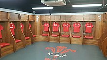 The home dressing room for the Welsh rugby union team, with a modern stylised version of the badge printed on its floor. Principality Stadium Dressing Room.jpg