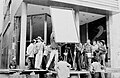 Escena de Chambú, en la Plaza de Caycedo en Pasto, con los tableros reflectores y la cámara de 35 mm. rodando una escena. El productror ejecutivo Enrique Gutiérrez y Simón observa la escena llevando en bandolera la cámara de 35 mm.