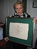 A woman holding a large diploma with her both hands