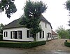 Boerderij, witgepleisterd dwarshuis met rieten afgewolfd zadeldak, kleine roedenverdeling, schuiframen