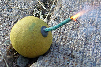 A smoke bomb with a lit fuse Smoke bomb with burning fuse.jpg
