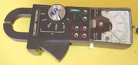 A multimeter with built-in clamp. Pushing the large button at the bottom opens the lower jaw of the clamp, allowing the clamp to be placed around a conductor. Tongtester.jpg