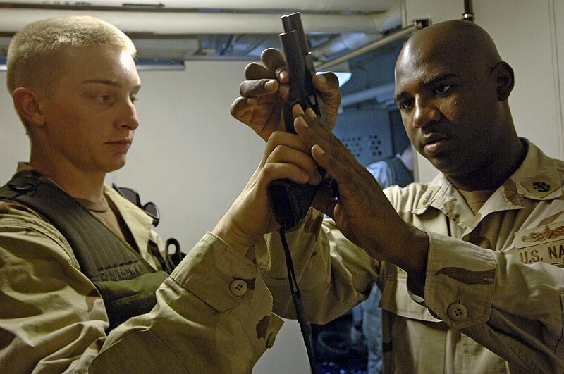 File:US Navy 061118-N-8148A-271 U.S. Navy Gunner's Mate Seaman Randy Barnes, left, assigned to Mobile Security Squadron Three (MSS-3), shows Chief Master at Arms Cephia Batson that his 9mm pistol is clear and safe to holster during.jpg