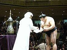 Tochiazuma during the presentation of trophies for his January 2006 yusho. United Arab Emirates trophy (sumo).jpg