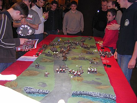 People gathered around a game of Warhammer. Warhammer game.jpg