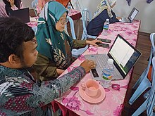 A Wikimedian teaching a teacher how to edit Wikisource.