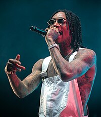 Wiz Khalifa (pictured) collaborated with Cyrus on two songs in 2013. Wiz Khalifa Stavernfestivalen 2018 (231826) (cropped).jpg